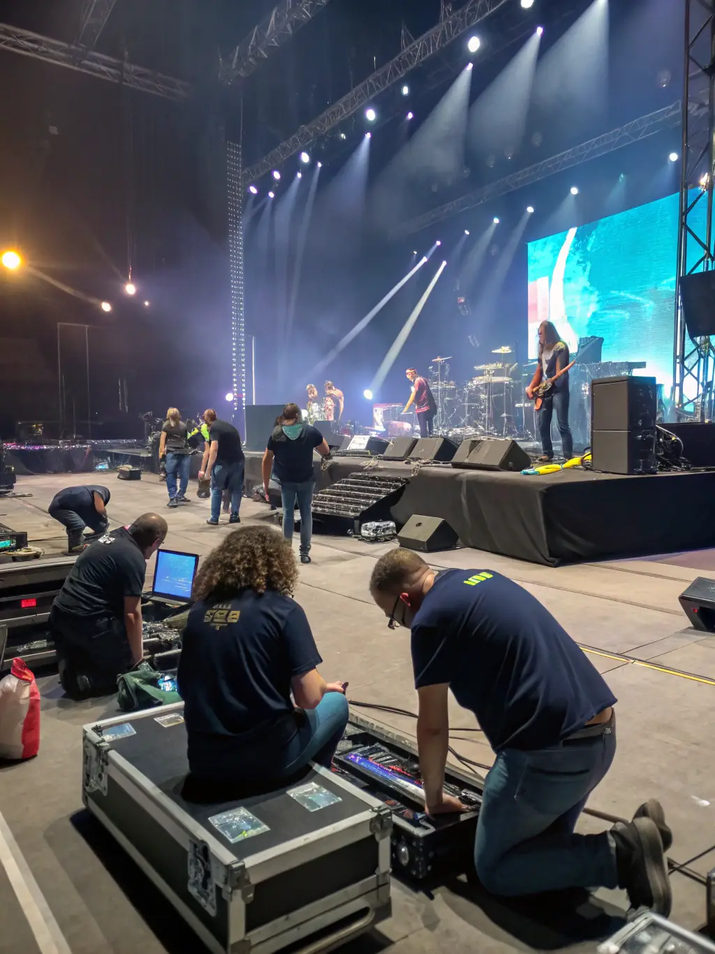 A behind-the-scenes shot of volunteers and staff collaborating to ensure the smooth running of the theatre festival, emphasizing teamwork.